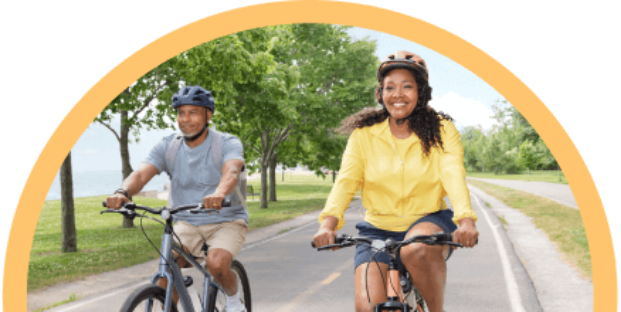 Pareja sonriente montando bicicleta al aire libre